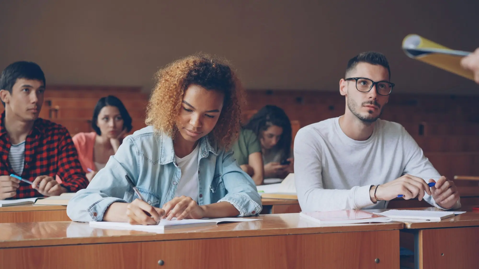 Students taking notes in a lecture hall